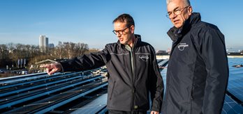 Twee medewerkers inspecteren de zonnepanelen