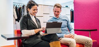 Twee medewerkers kijkend naar een tabletscherm